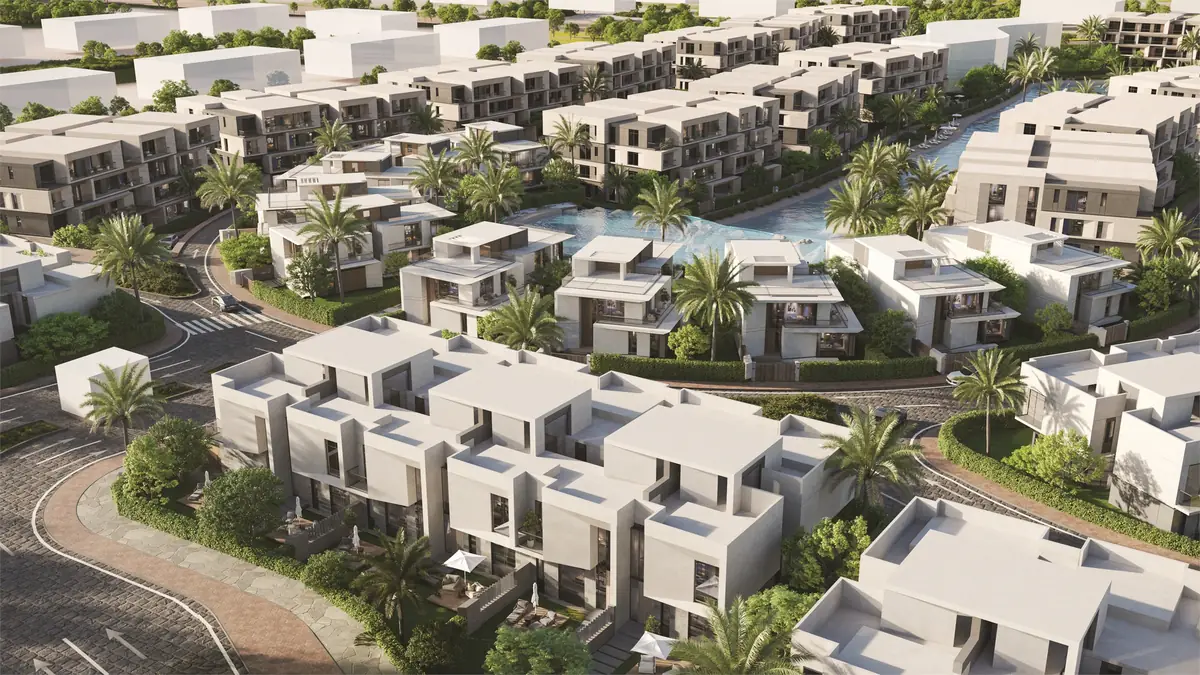 31 West – Aerial view of white townhouse clusters and palms around a winding lagoon
