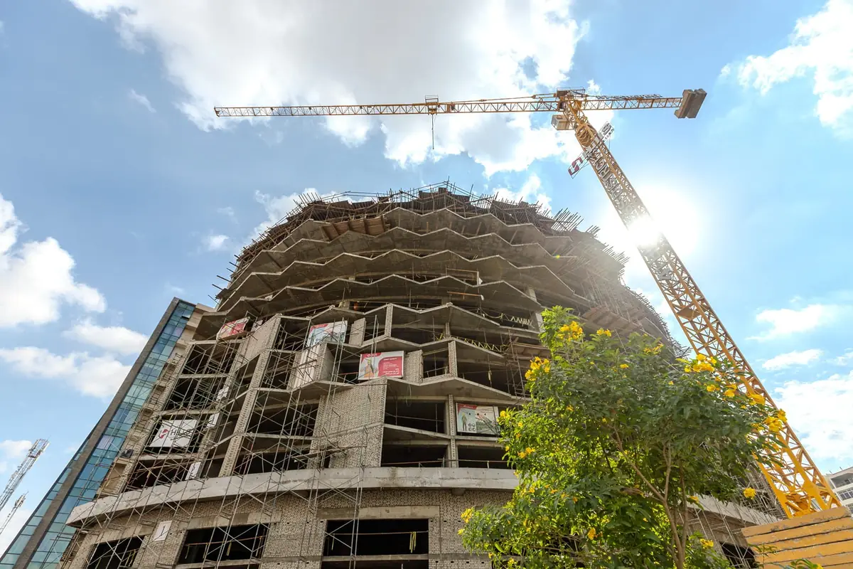 41 Business District – Untersicht auf den geschwungenen Betonrohbau und den Turmdrehkran während der Bauphase