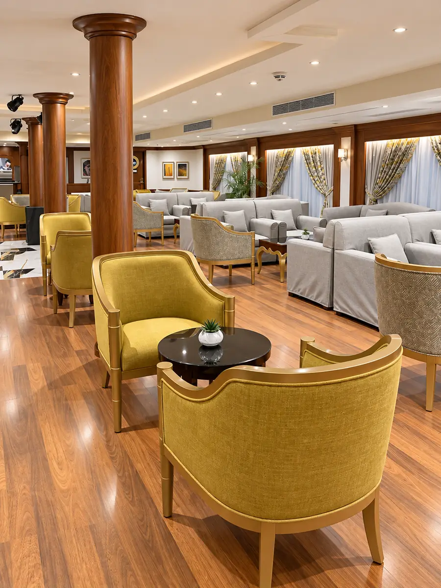 Amwaj Boat Renovation – Lounge with mustard armchairs, grey sofas and timber columns