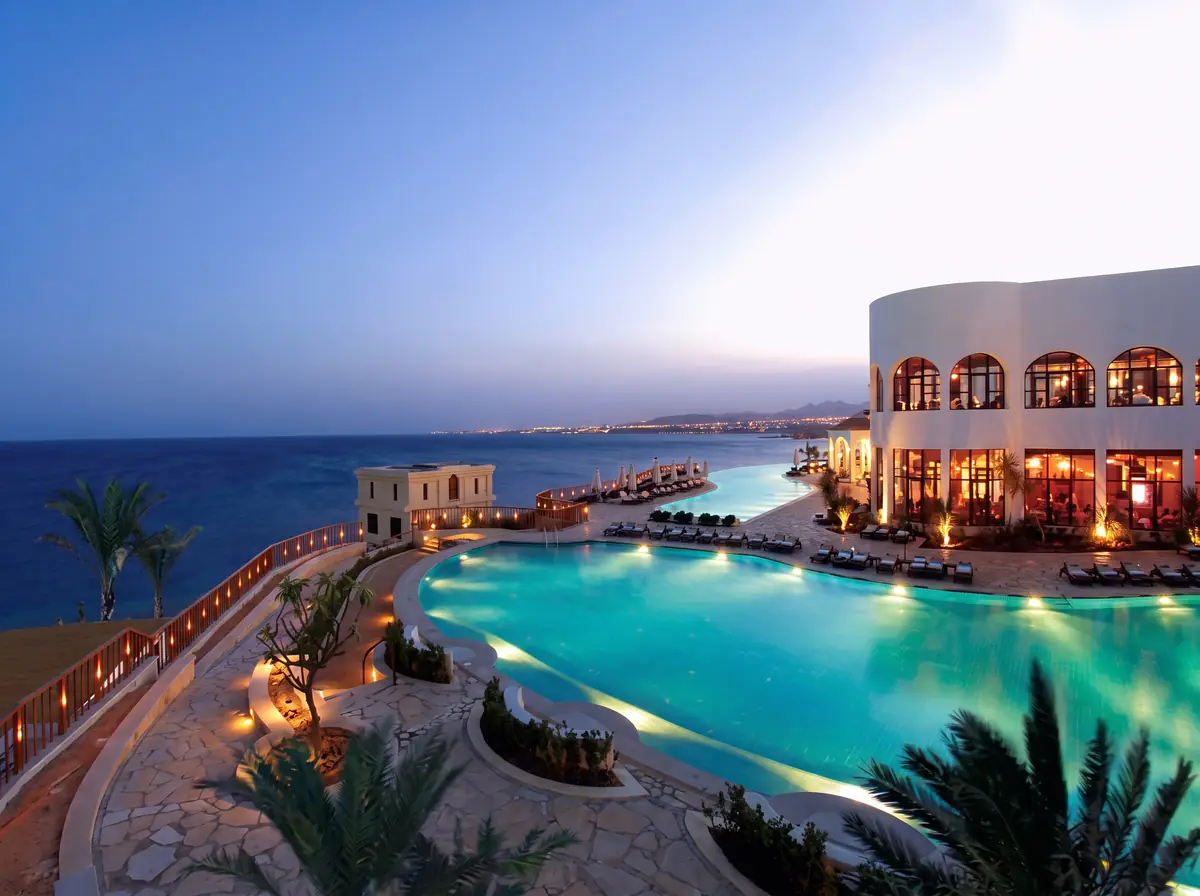 Blue Bay Resort Thalassotherapy Spa – Terraced pool deck at dusk overlooking the Red Sea coastline