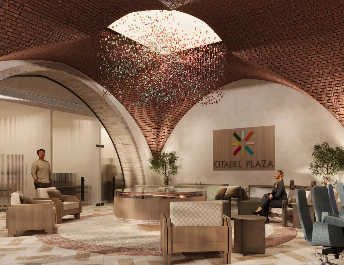 Citadel Plaza Sales Office – Angled view toward a glass meeting room through a travertine arch