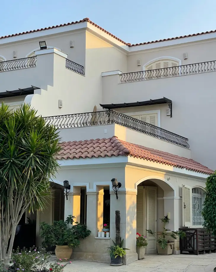 Green Heights Compound – Villa corner with tiled roofs, wrought-iron balconies and an arched porch