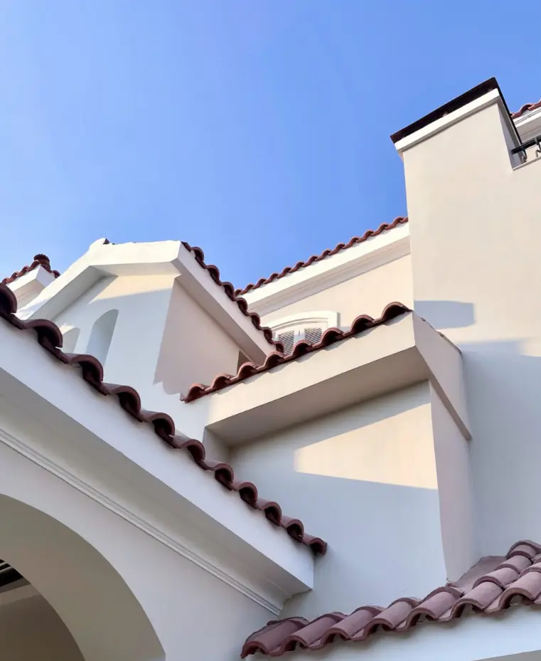 Green Heights Compound – Close-up of terracotta roof eaves against white walls and blue sky