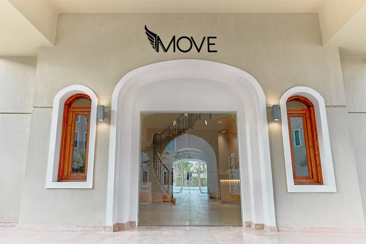 Move – Green Heights Sports Complex – Arched entrance doorway with timber-framed windows and a glimpse of the spiral stair