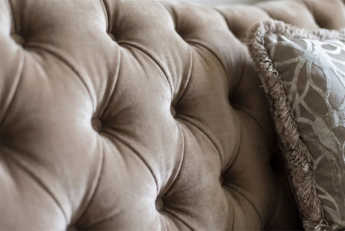 Mrs. M.A.'s Villa – Close-up of tufted velvet upholstery with a fringed patterned cushion