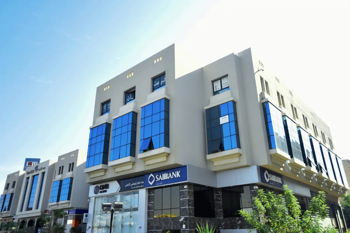 Prima Vista – Medical Office & Commercial Mall – Low corner view of the bay-windowed façade above bank branches clad in dark marble
