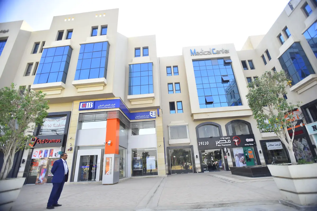 Prima Vista – Medical Office & Commercial Mall – Ground-floor shops and banks below the glazed medical centre bay, with plaza trees