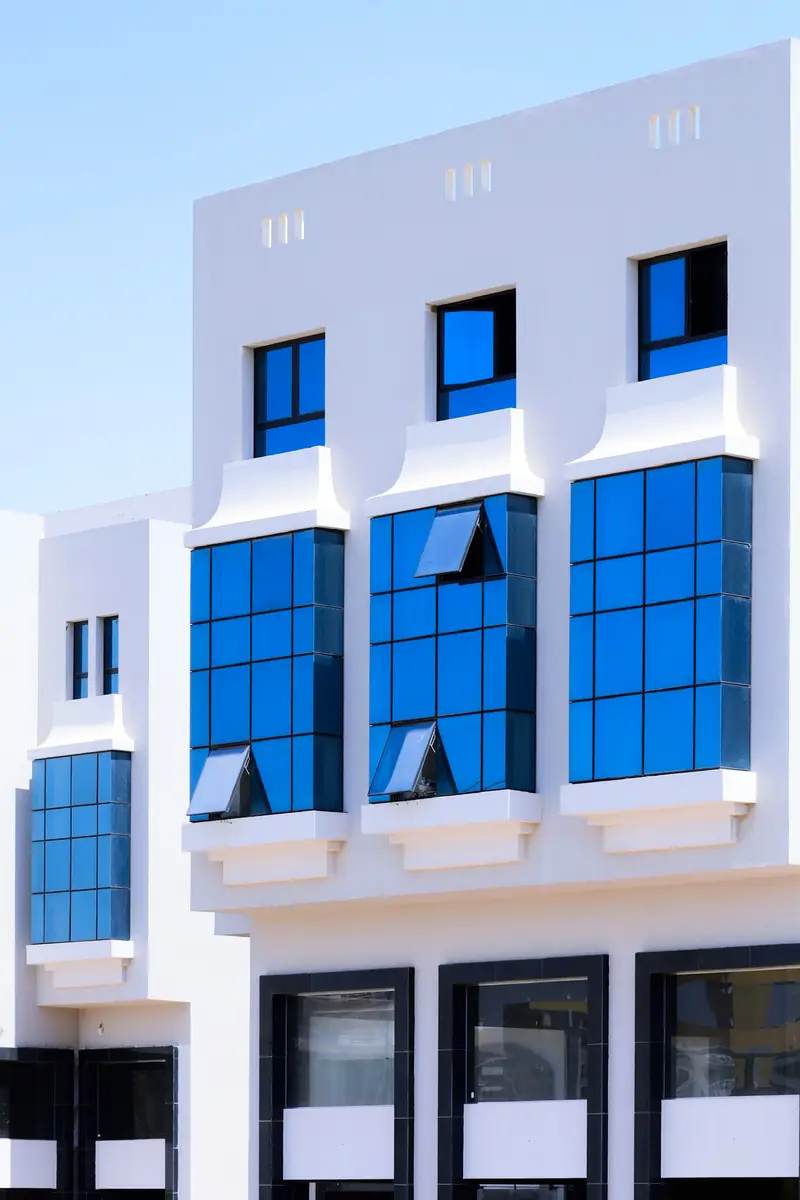 Prima Vista – Medical Office & Commercial Mall – Bright white façade with vivid blue glass bays and top-hung vents