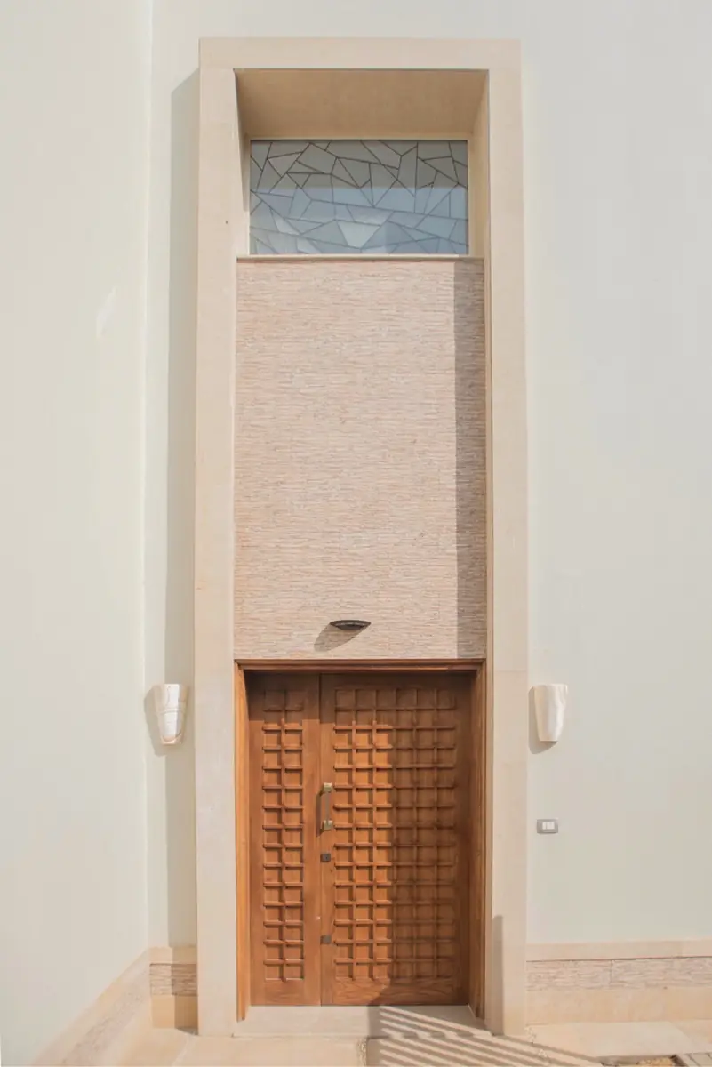 Prof. Dr. H.F.'s Villa – Tall entrance with coffered timber double door, stone niche and patterned glass transom