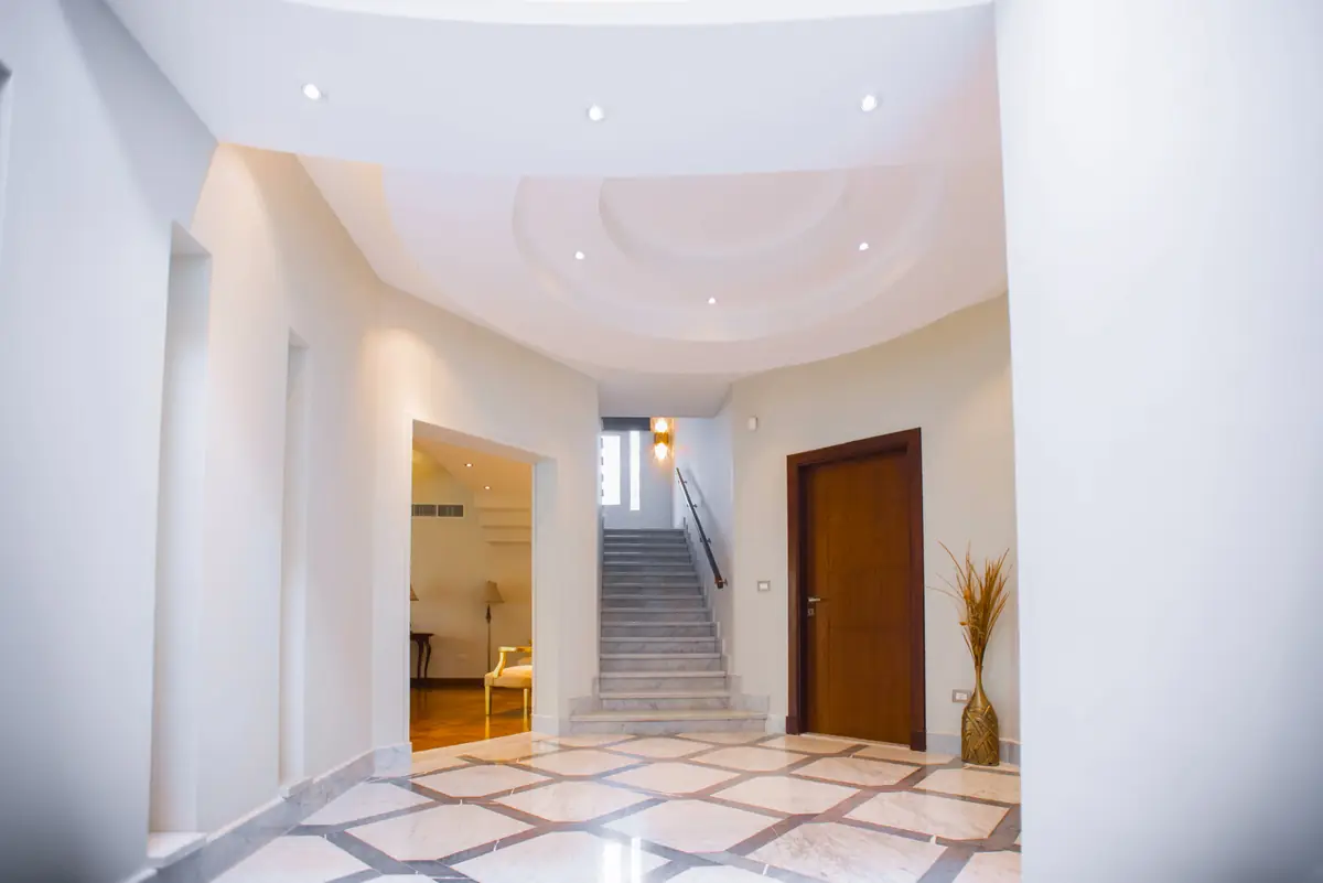 Prof. Dr. H.F.'s Villa – Curved entrance hall with geometric marble floor and a staircase