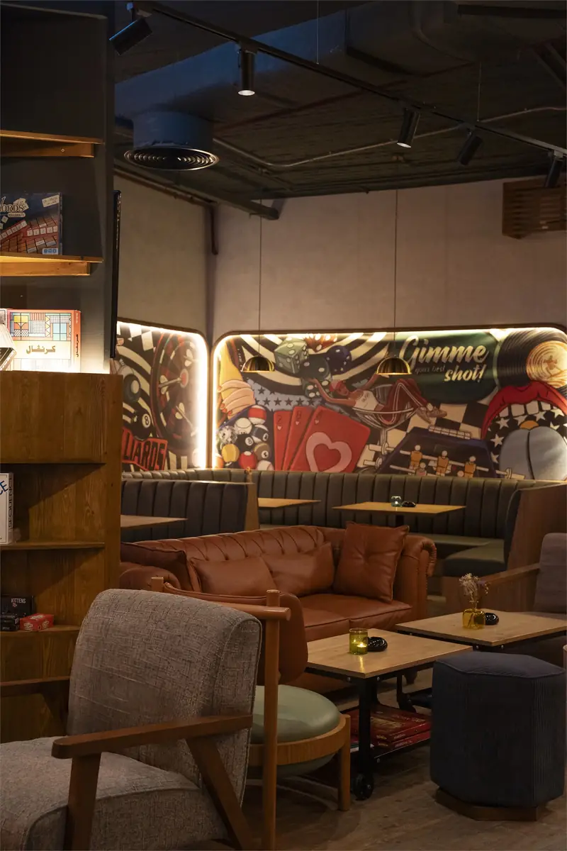 Rush – Sports Bar – Lounge mit Ledersofa, Spieleregal und hinterleuchtetem Pop-Art-Wandbild hinter den Sitznischen