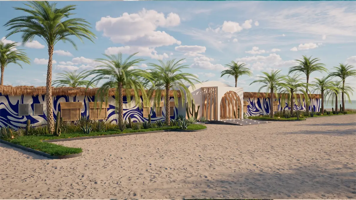 The Spot – Kite Center – Umfassungsmauern mit blauen Wellenmustern hinter Palmen und Sand