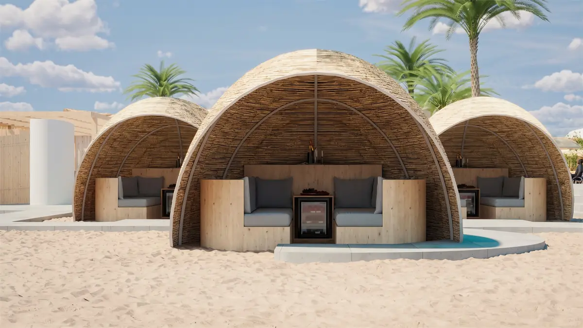 The Spot – Kite Center – Geflochtene Kuppelkabanas mit grauen Sitzpolstern auf dem Sand